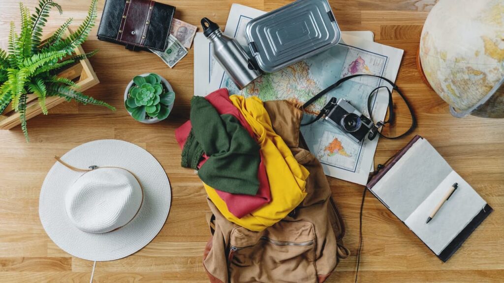 A flat lay top view desktop with maps and other travel essentials